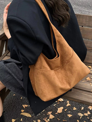 Large brown suede shoulder bag with exterior pockets.