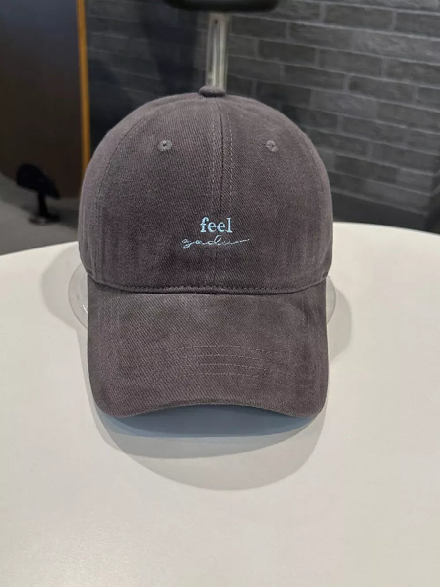 Gray baseball cap with embroidered "feel good" text detail.