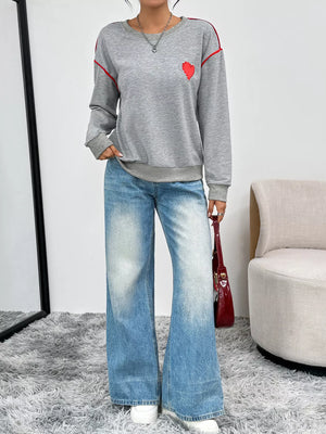 Gray sweatshirt with red heart embroidery and red stripe accents, crew neck, long sleeves.