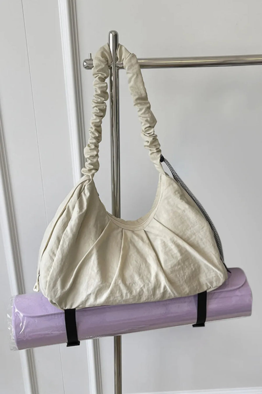 Gathered crescent shoulder bag in beige with ruched strap and pleated detail
