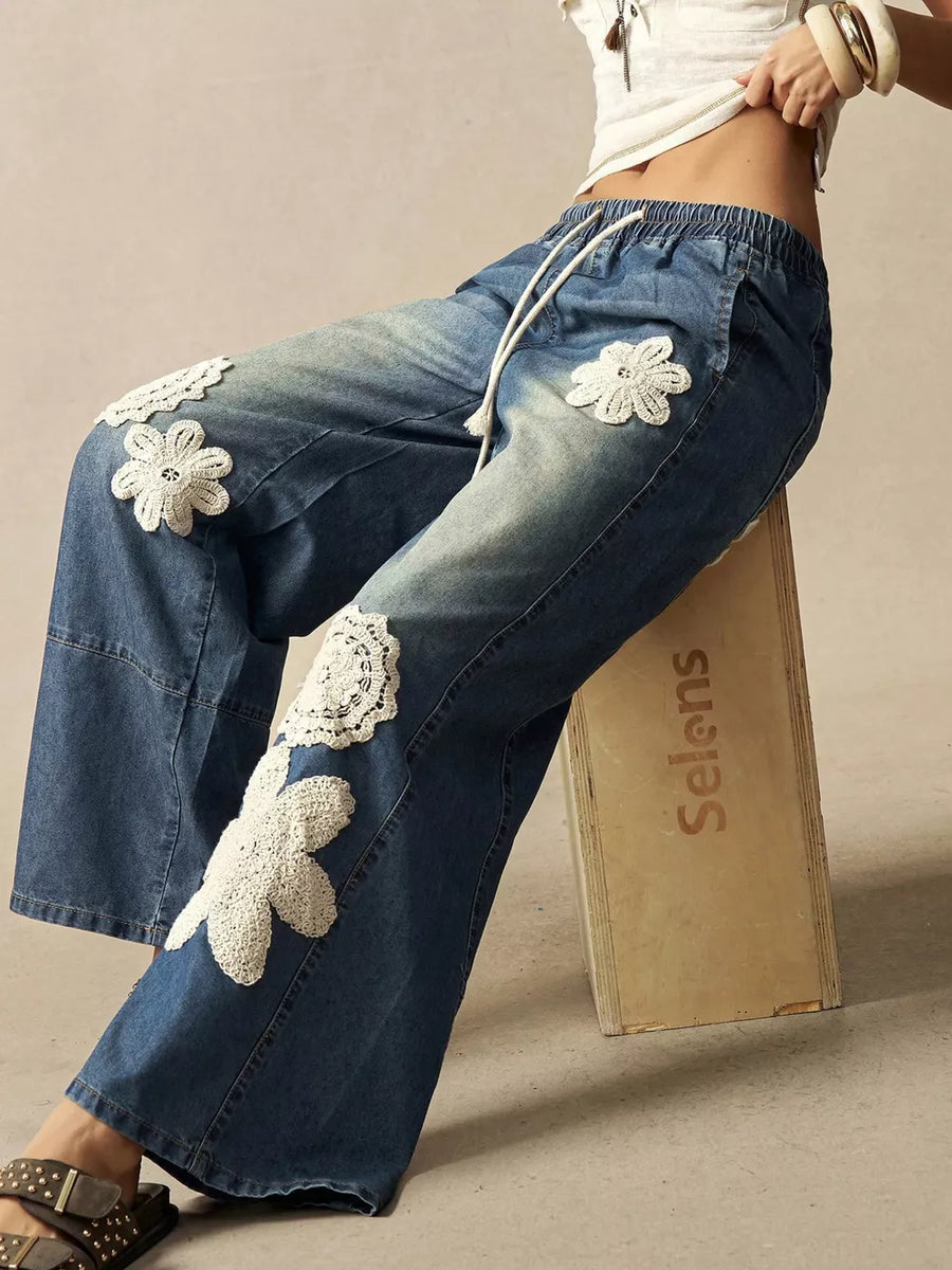 wide-leg jeans in medium wash blue featuring drawstring waist and flared fit