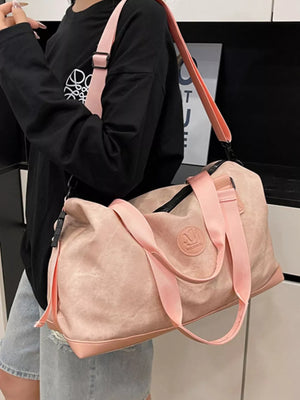 Pink Oxford cloth duffel bag with pink straps and leather trim.