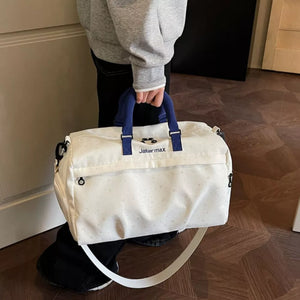 Starry Night Lightweight Duffel Bag in cream white with crescent moon pattern and blue handles.