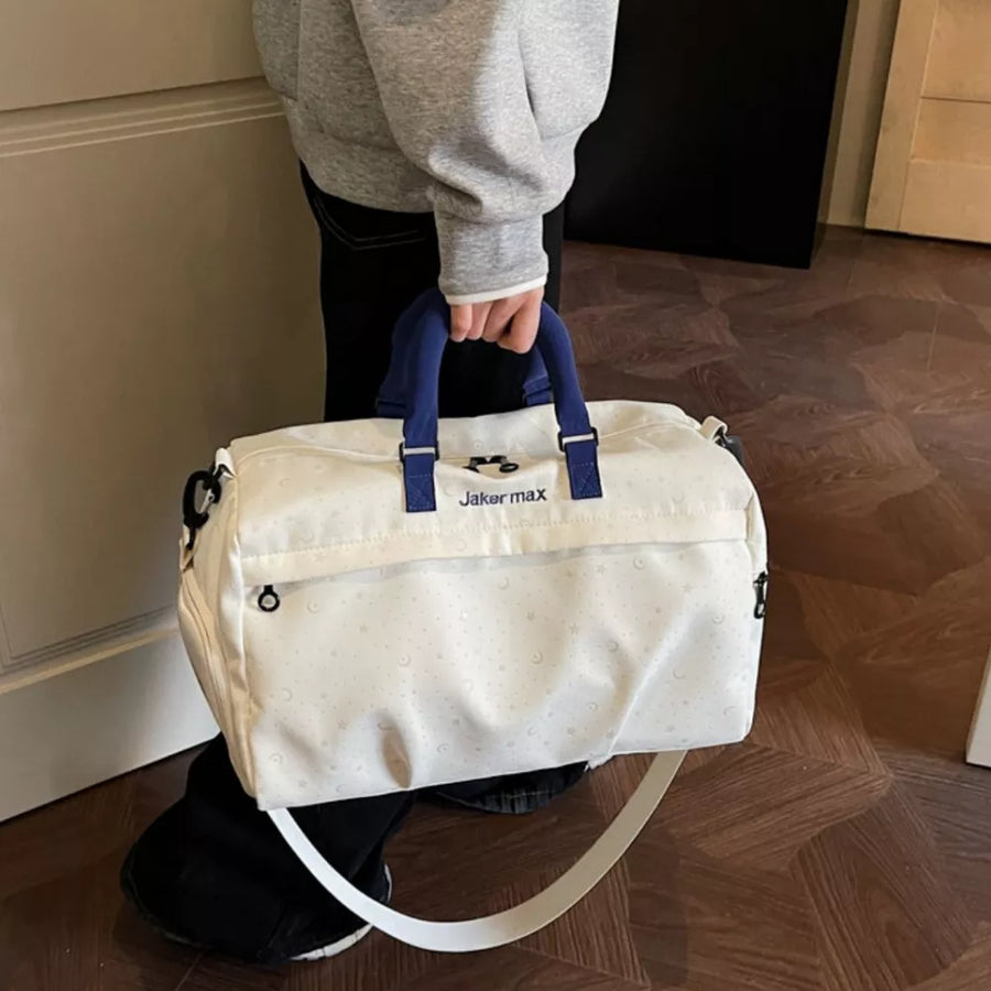 Starry Night Lightweight Duffel Bag in cream white with crescent moon pattern and blue handles.