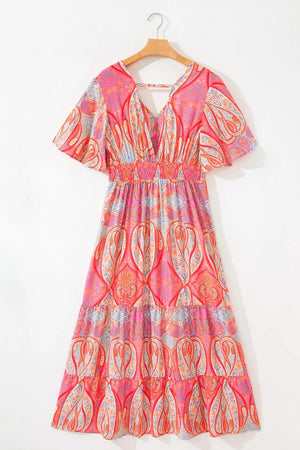 Paisley print boho dress with V-neck, short sleeves, smocked waist, and tiered skirt in burnt coral.
