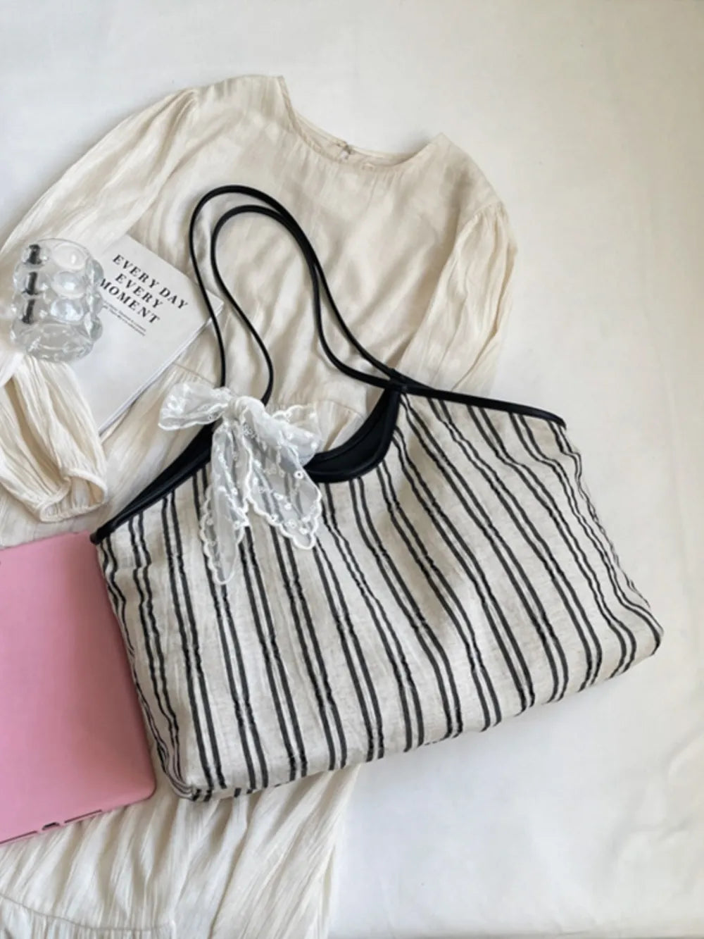 Lace bow striped shopper bag in beige with black straps and trim.