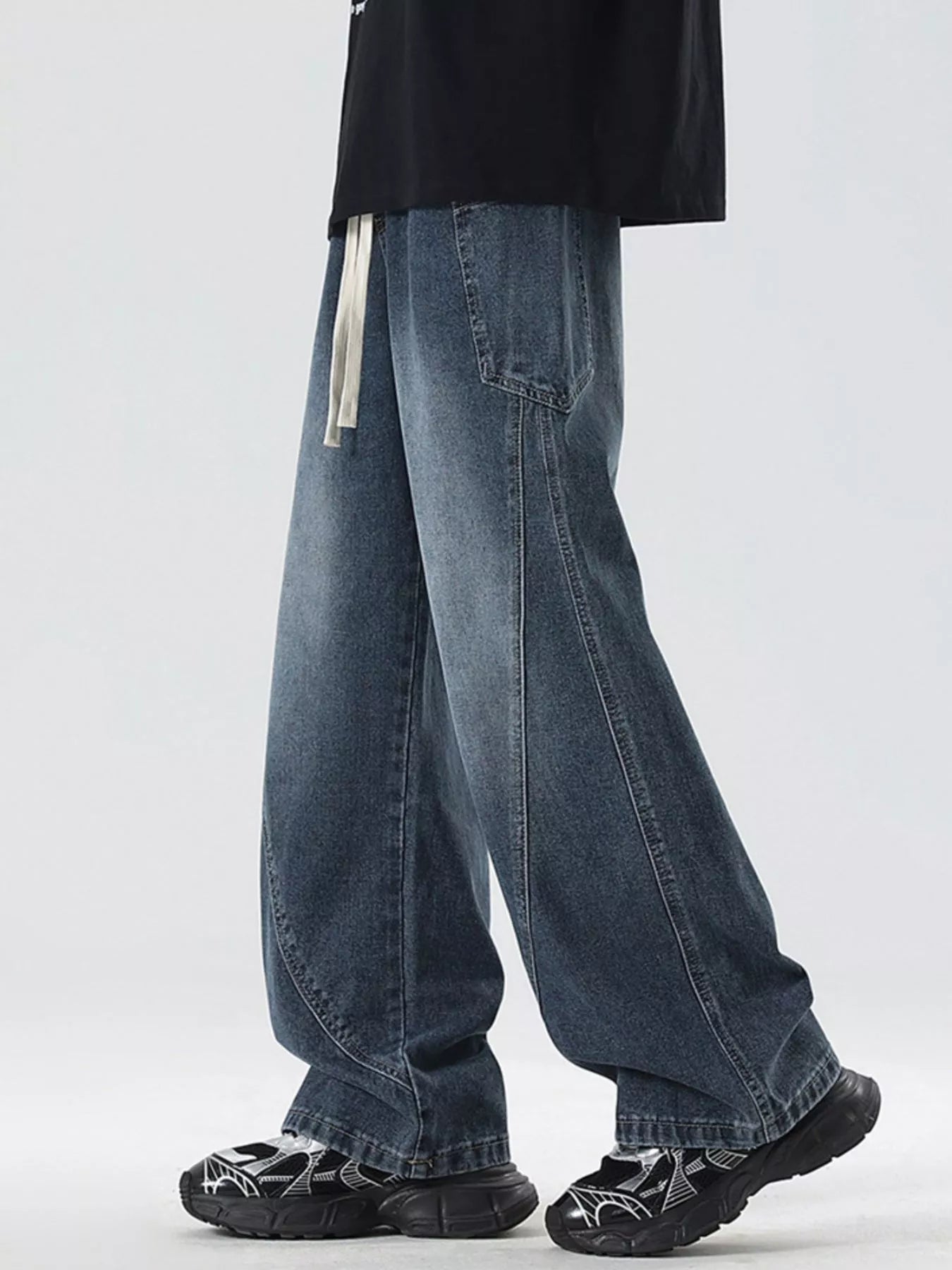Oversized wide-leg jeans in blue denim with a drawstring waist and vintage wash.
