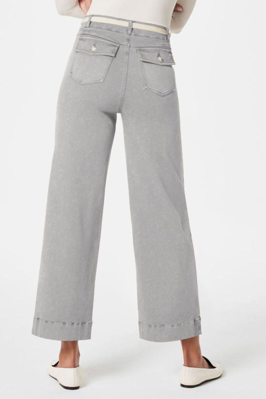 Wide-leg utility denim trousers in light gray with buttoned back pockets and a white belt.