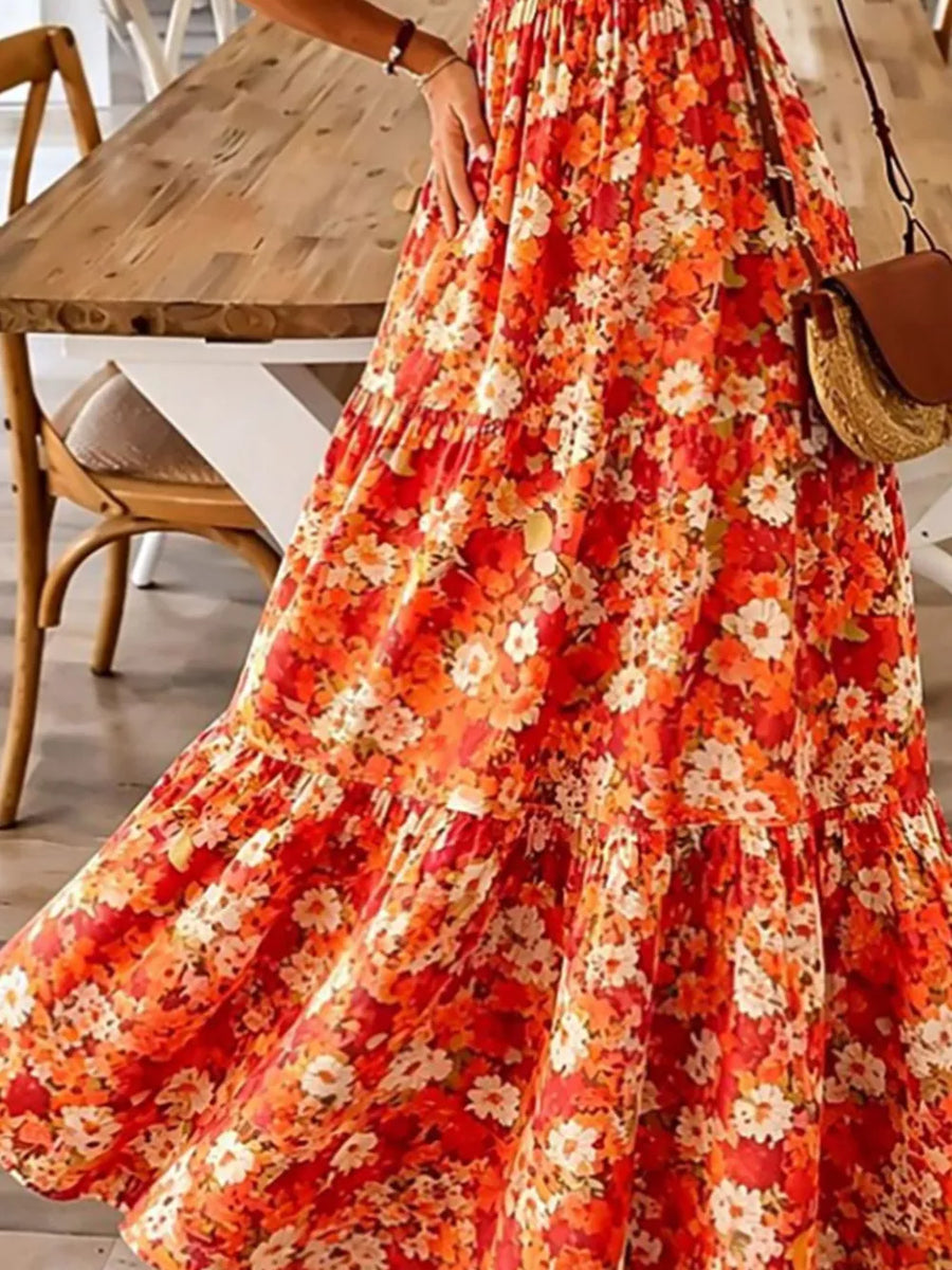Orange floral tiered maxi dress with spaghetti straps and ruffled hem.