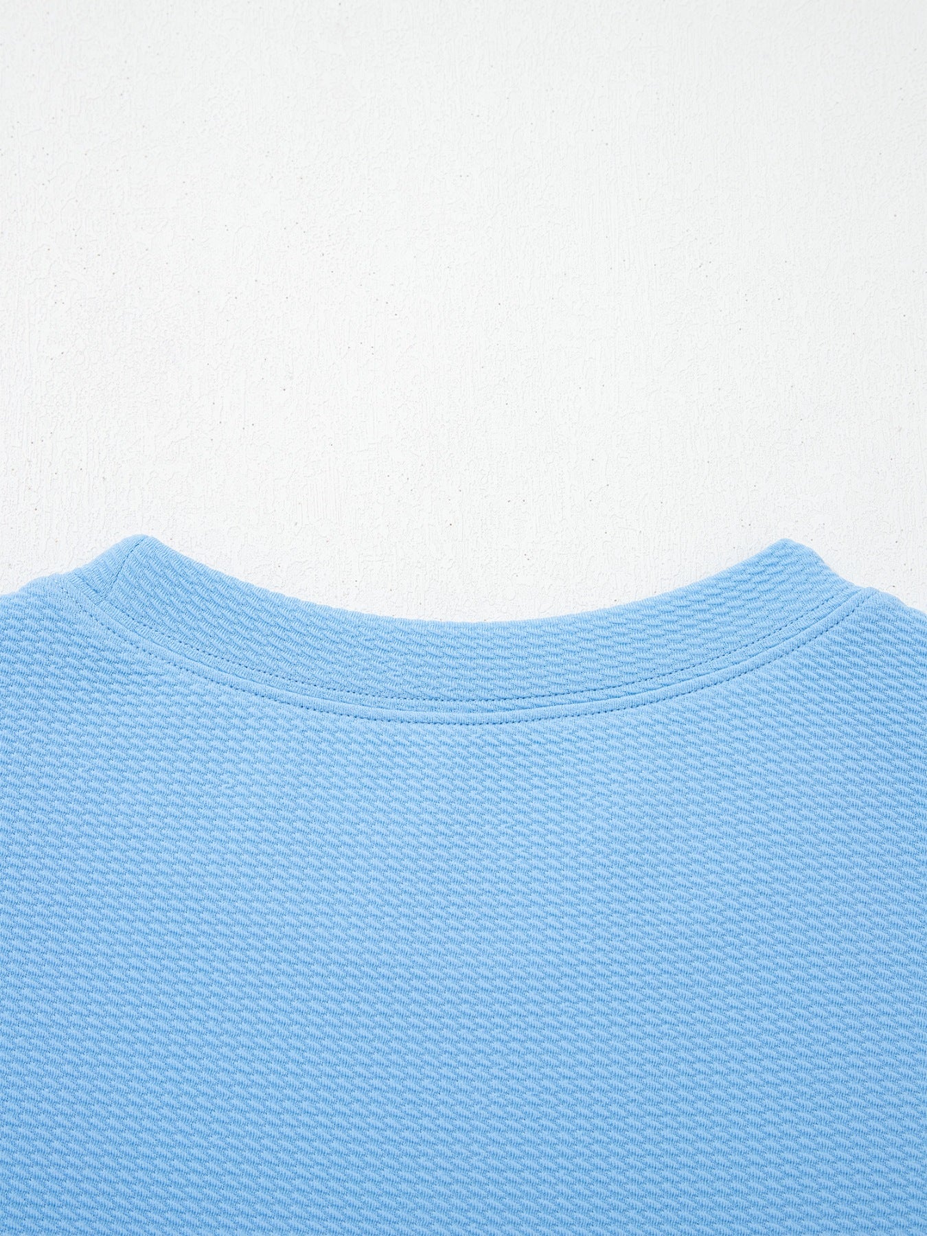 Textured blue blouse with crew neck and bubble sleeves
