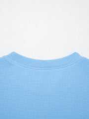 Textured blue blouse with crew neck and bubble sleeves