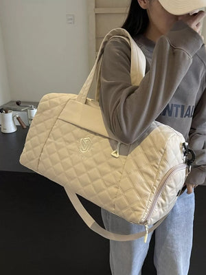 Diamond-stitched beige quilted duffel bag with adjustable strap and zippered compartment.