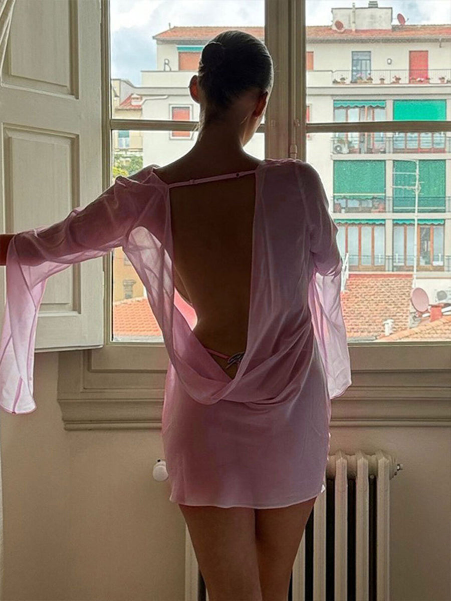 Pink chiffon backless mini dress with draped detail and long sleeves.