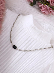 White ribbed dress with a silver chain necklace featuring a black gem detail.