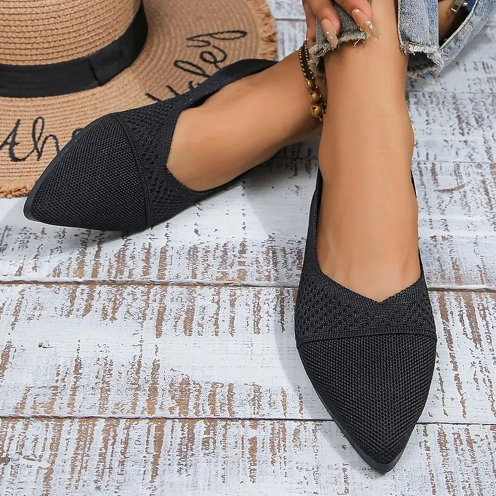 Black knit pointed toe flats with a V-shaped vamp and subtle texture detail.