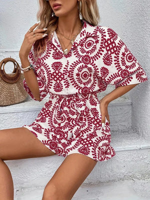 Deep Red printed tie-waist romper with button front and short sleeves.