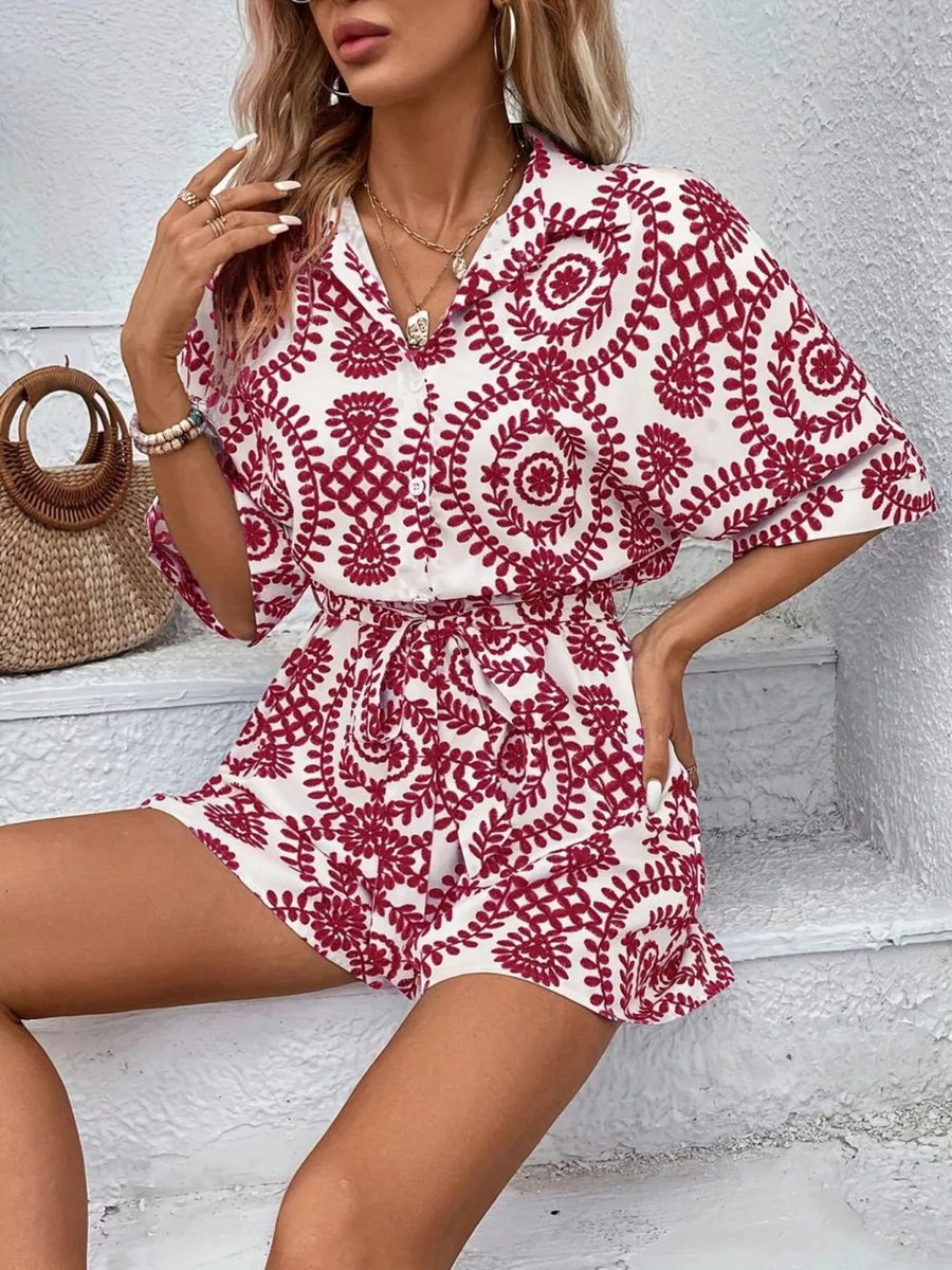 Deep Red printed tie-waist romper with button front and short sleeves.