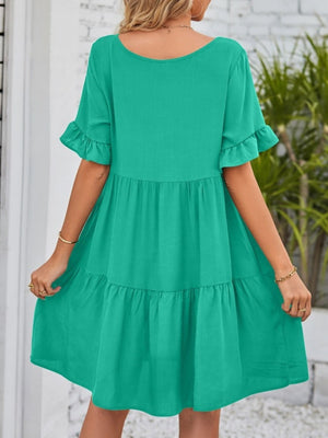 Emerald green tiered mini dress with ruffled short sleeves and pockets.