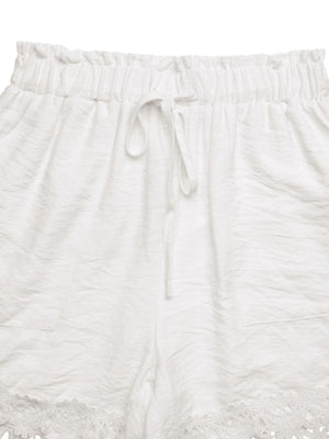 White drawstring waist shorts with lace trim and textured fabric.