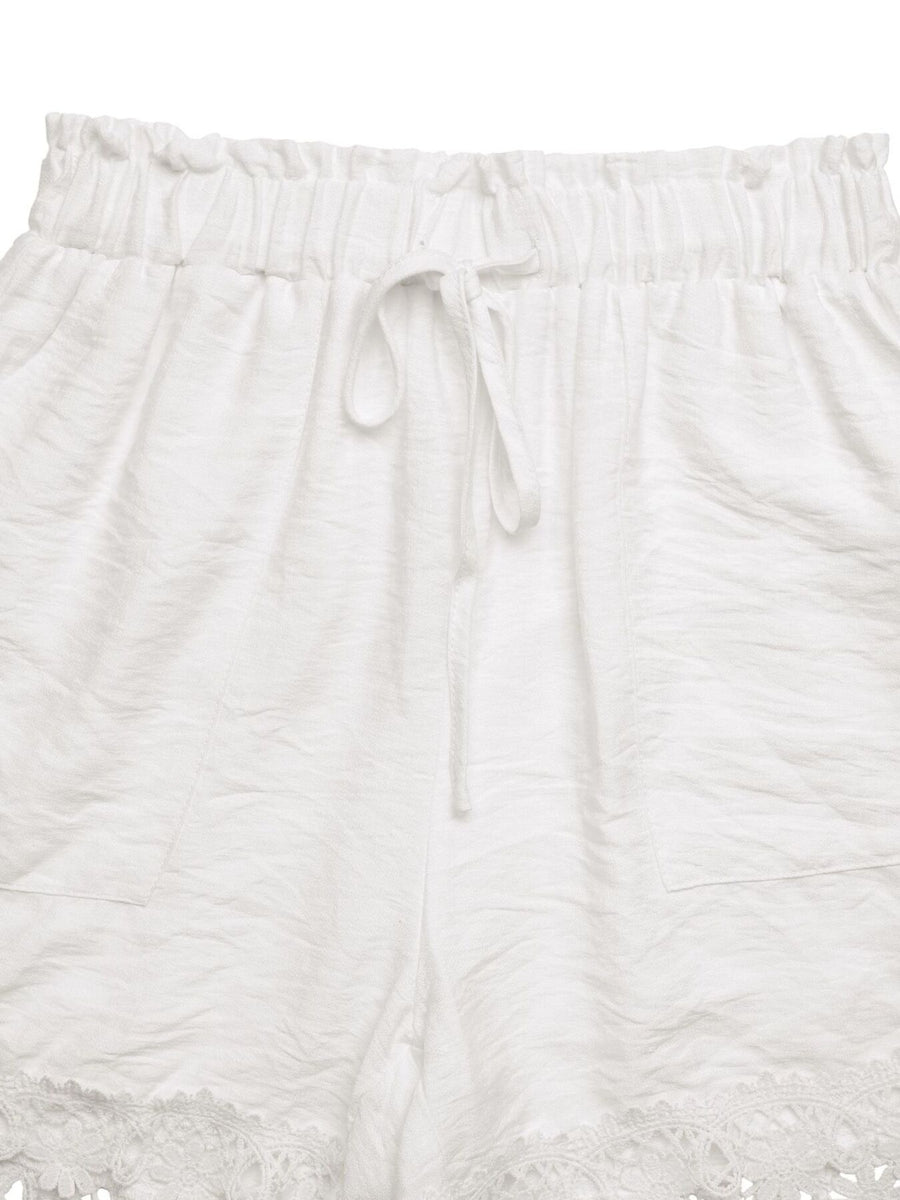 White drawstring waist shorts with lace trim and textured fabric.