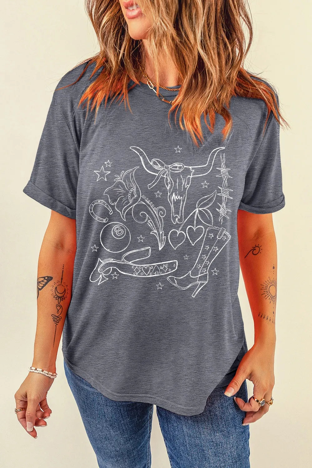 Gray t-shirt with white western tattoo graphic featuring a bull skull, boots, hearts, and horseshoe.