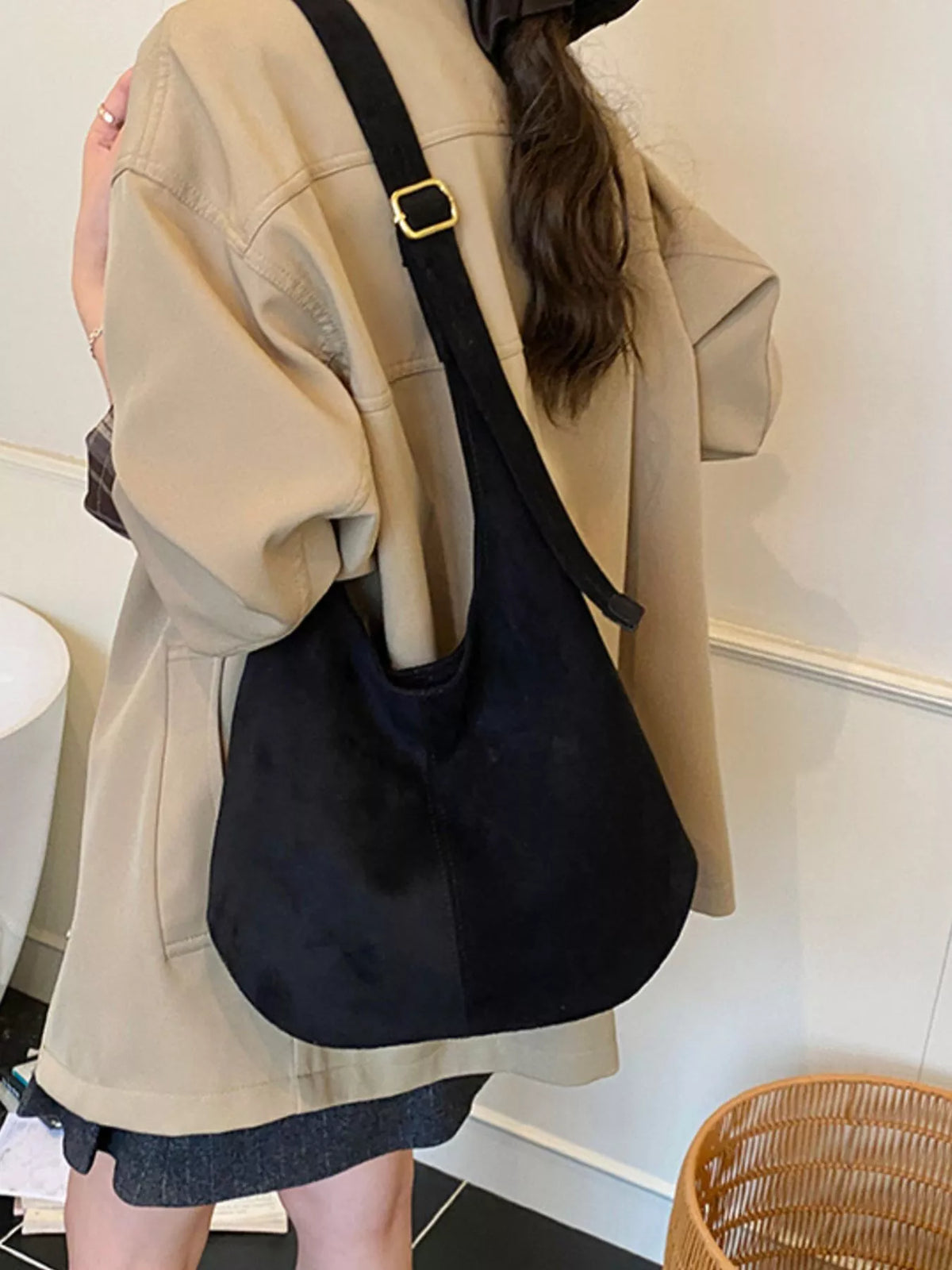 Large black suede hobo shoulder bag with gold buckle detail on strap