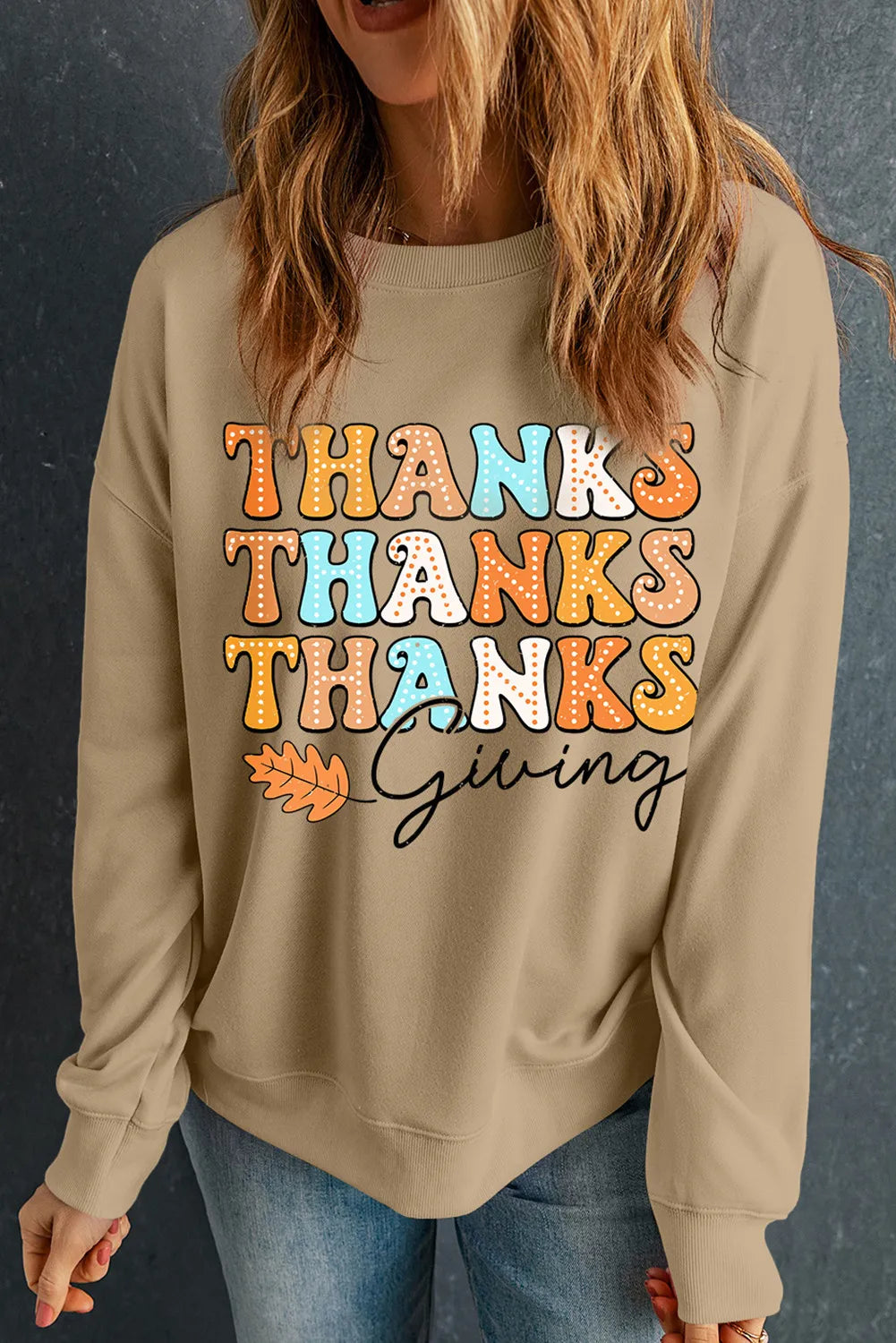 Khaki drop shoulder sweatshirt with stacked "Thanks" graphic and "Giving" text with a leaf accent.