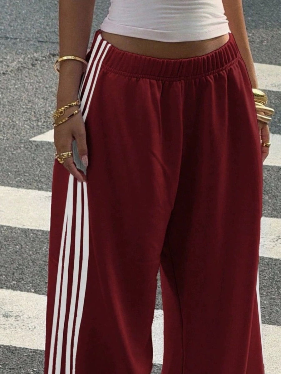 Navy track pants featuring high-waisted and striped