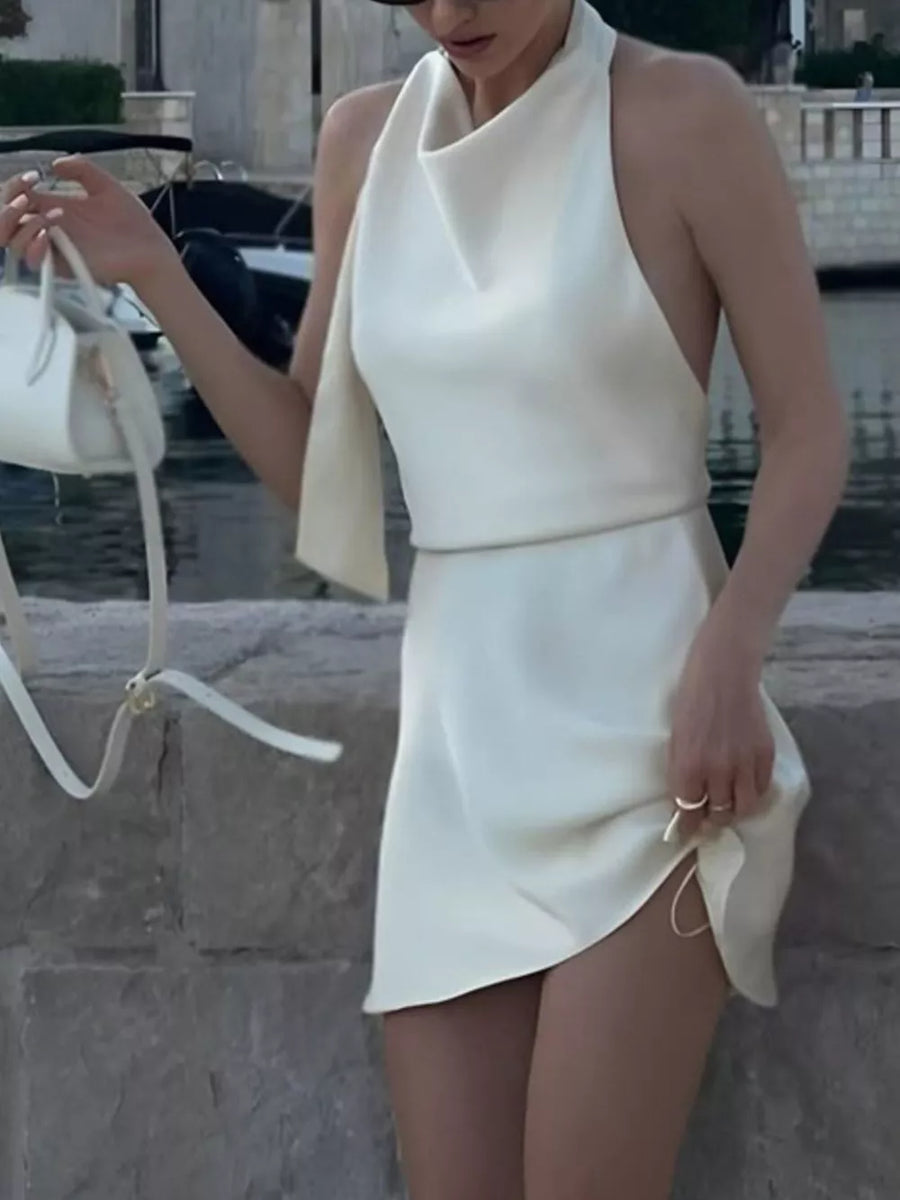 White halter neck mini dress with cowl neck and draped detail.
