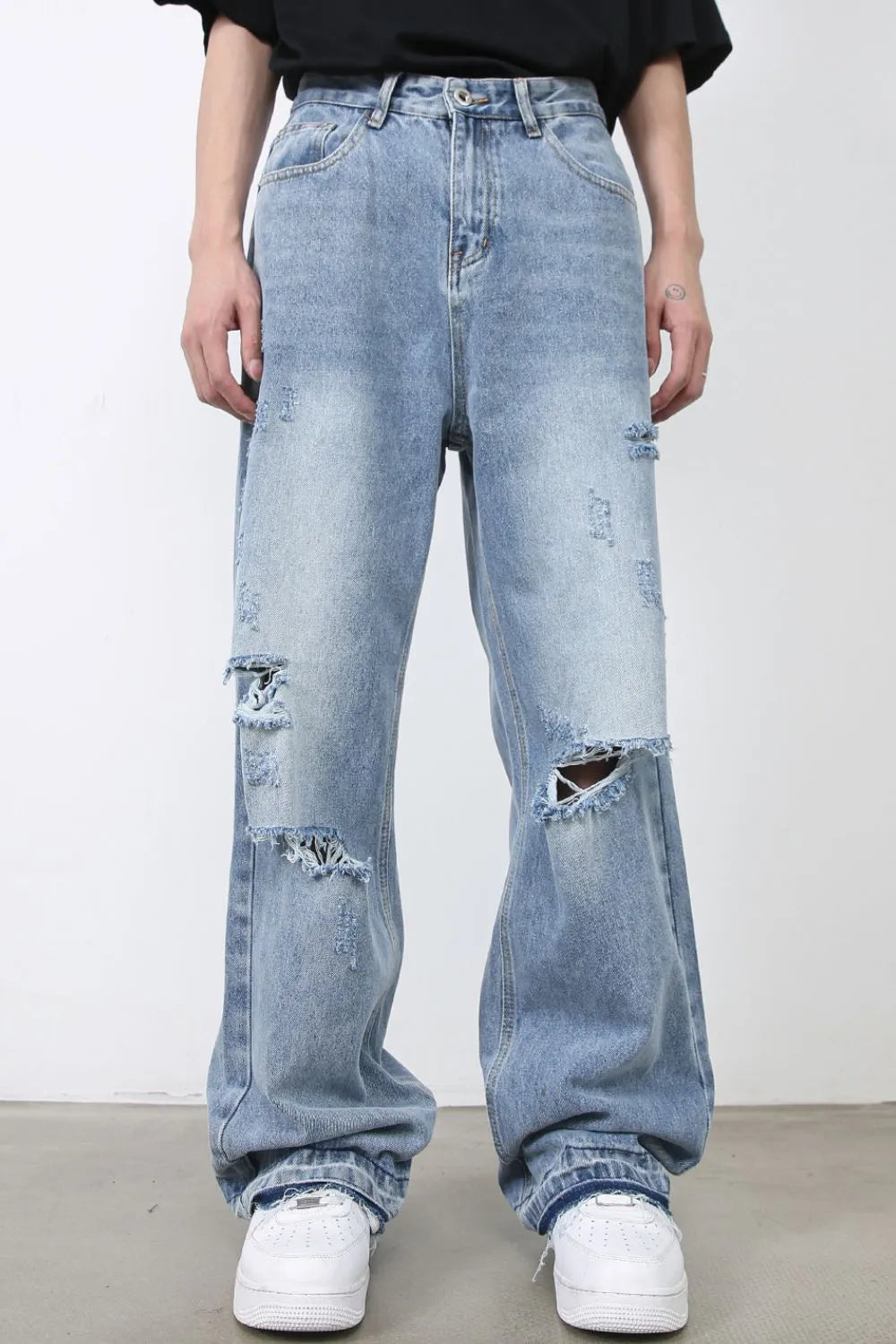 Light blue distressed wide-leg denim jeans with raw hem detail and rips.