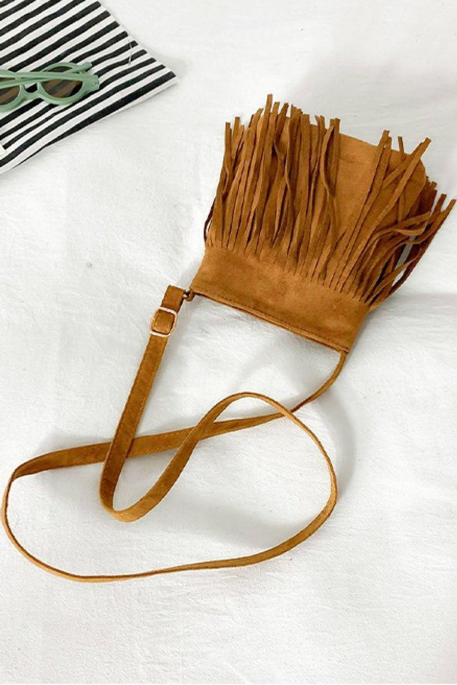Caramel suede crossbody bag with fringe detail and adjustable strap