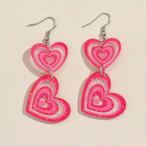 Pink glitter heart dangle earrings with layered pink acrylic hearts.