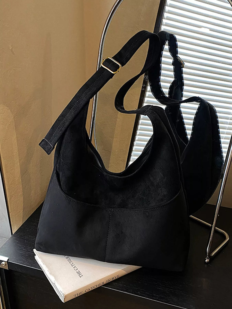 Black suede and fabric shoulder bag with adjustable strap and gold buckle detail.