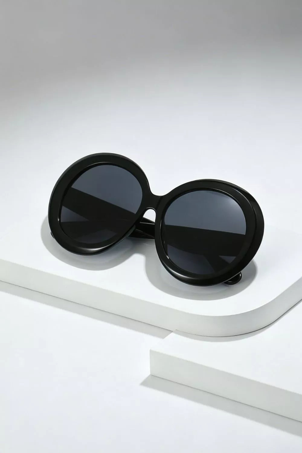 Chic oversized round black fashion sunglasses with dark lenses.