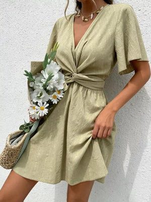 Twist waist mini dress in light green with flutter sleeves and a V-neck.
