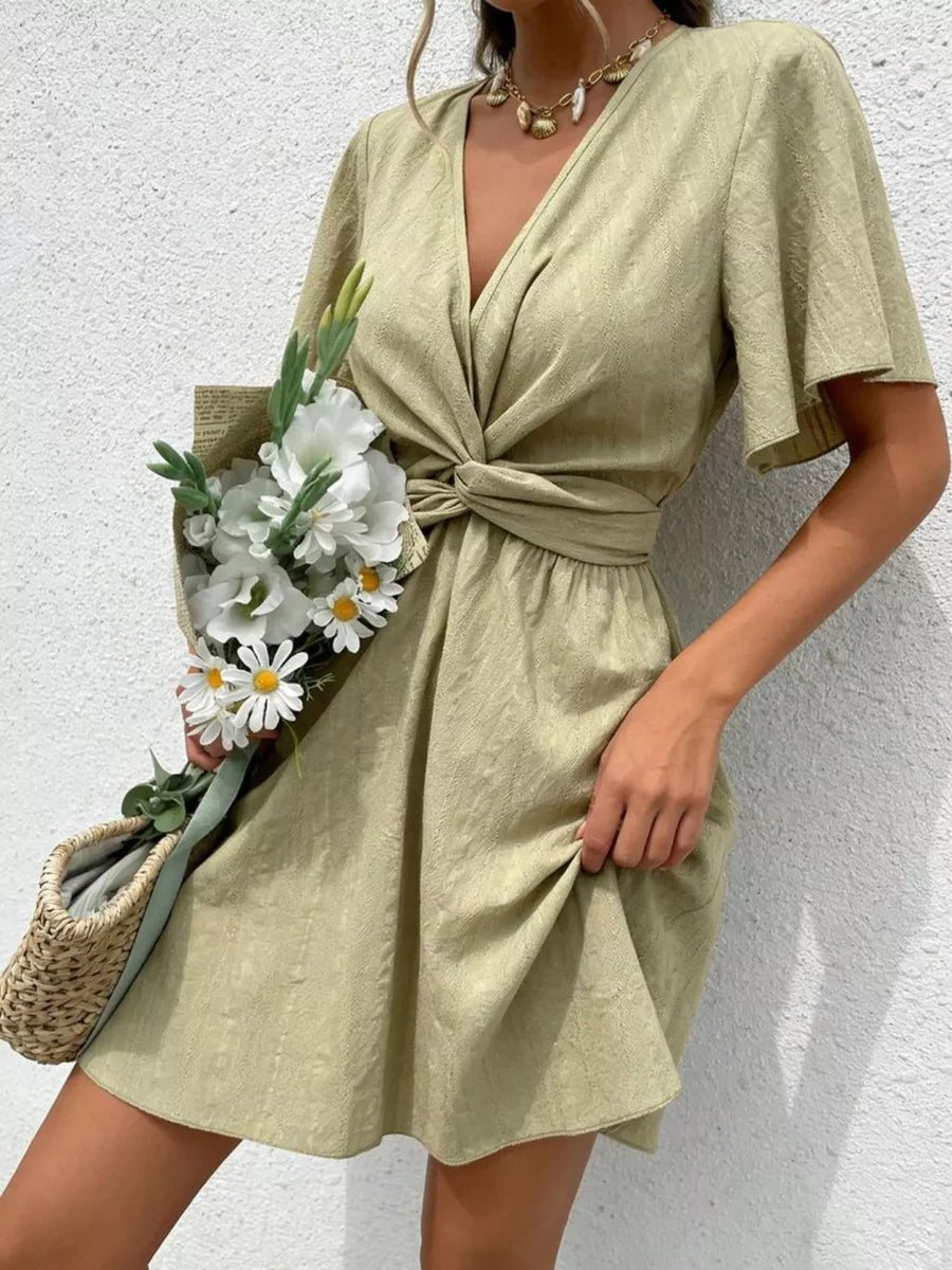Twist waist mini dress in light green with flutter sleeves and a V-neck.