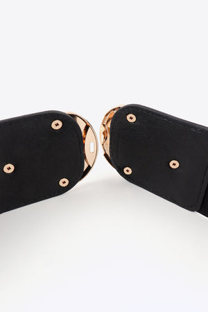Black elastic belt with double gold buckles and gold stud details.