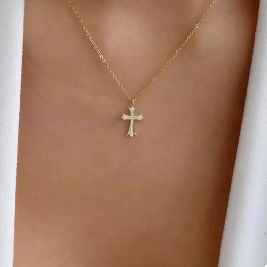 Gold rhinestone cross pendant necklace with delicate chain.