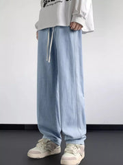 Light blue oversized drawstring jeans with a loose fit and vertical seam detail.