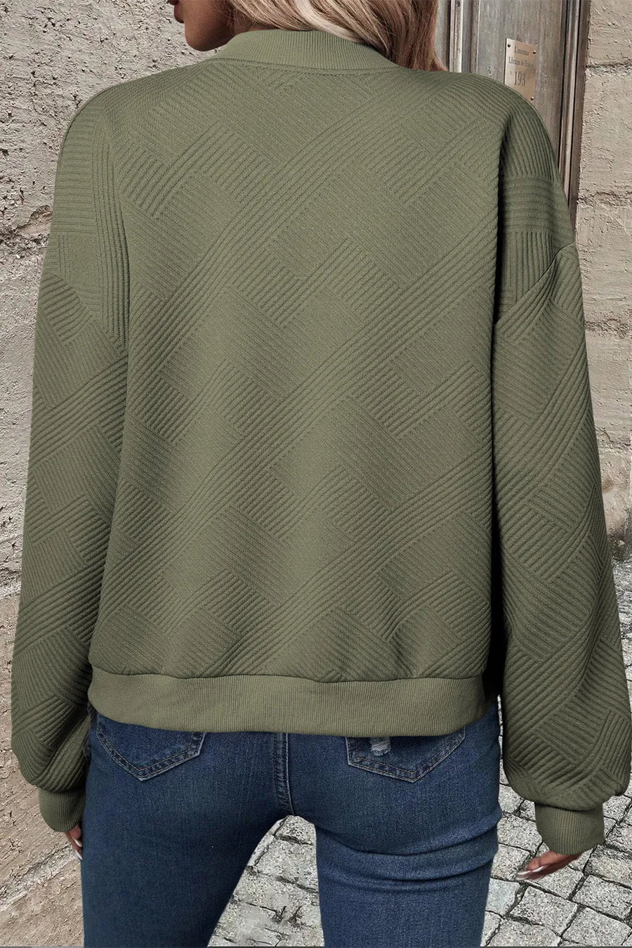 Textured quilted bomber jacket in sage green with a geometric pattern and ribbed cuffs.