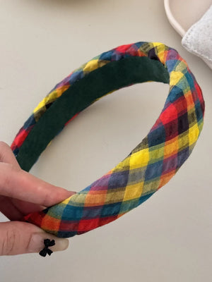 Padded plaid headband in multicolor with a dark green lining.