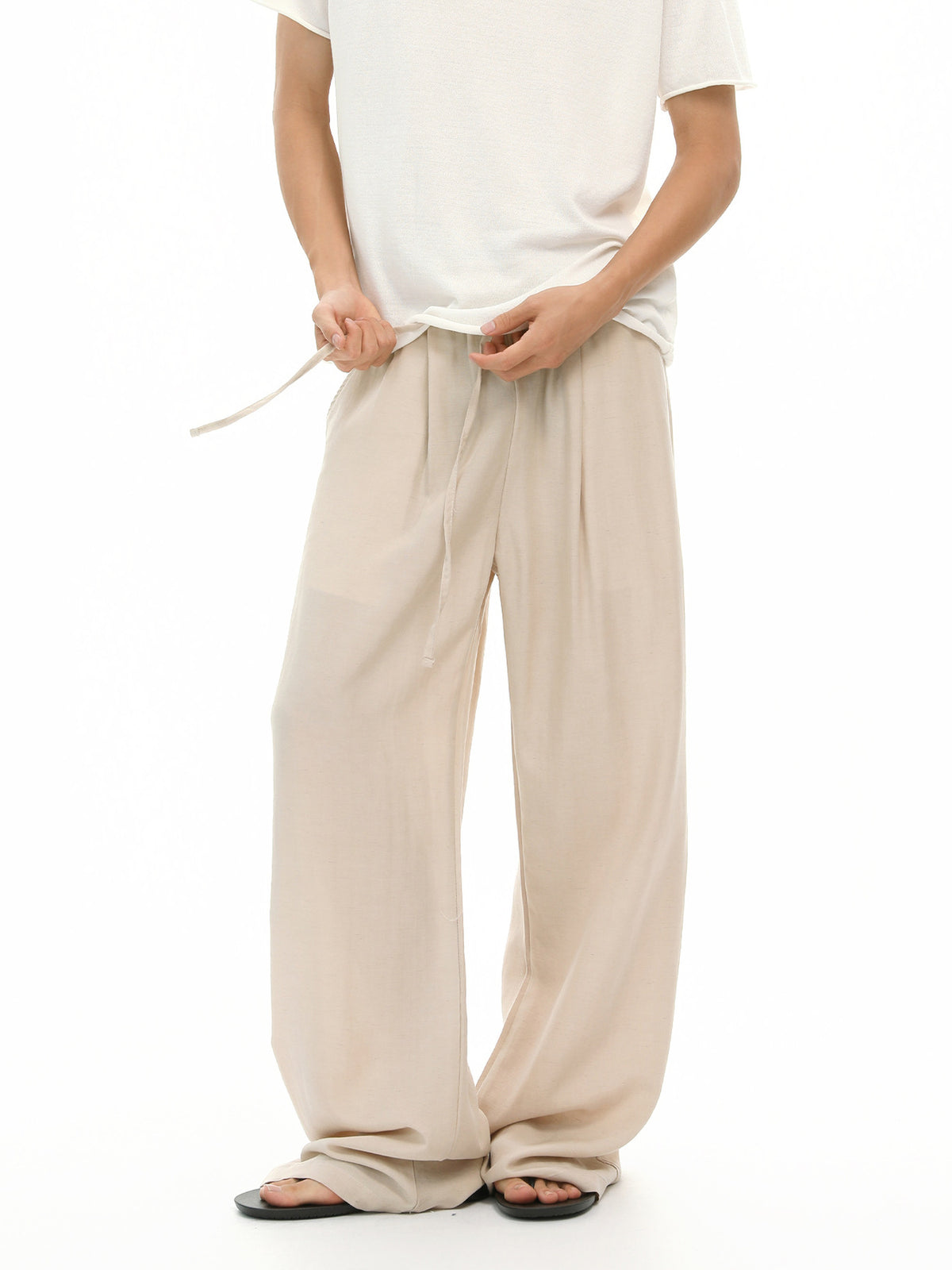 wide-leg pants in light beige featuring drawstring waist and loose fit