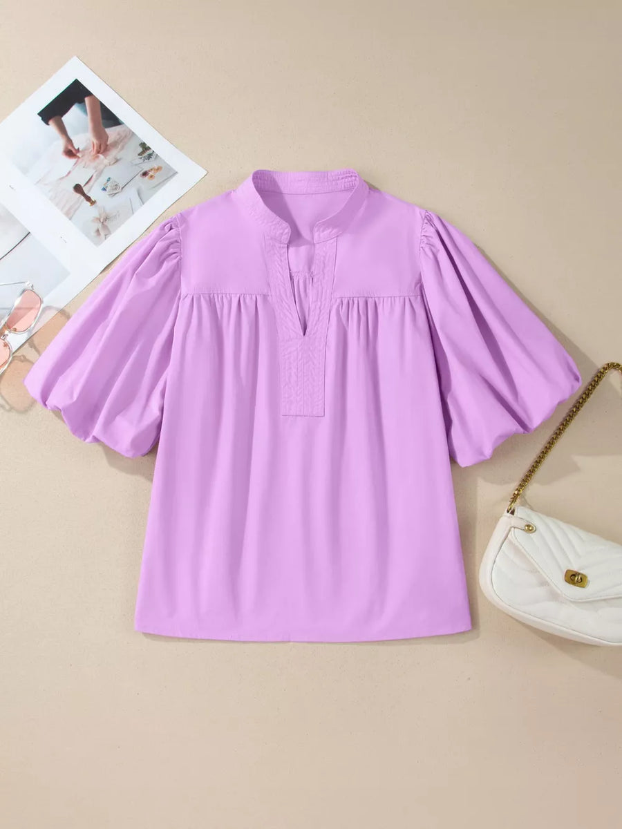Lavender cotton shirt with notched neckline and voluminous puff sleeves.