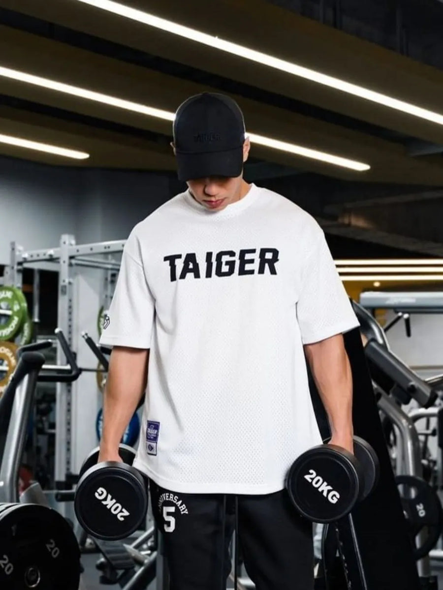 White mesh oversized t-shirt with black TAIGER graphic and short sleeves.