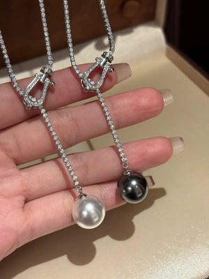 Lustrous pearl drop Y-necklace in dark gray and eggshell with diamond chain and horseshoe clasp.
