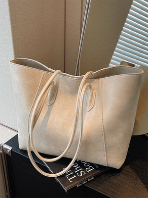 Off-white crinkled PU leather tote bag with double handles and a spacious interior.