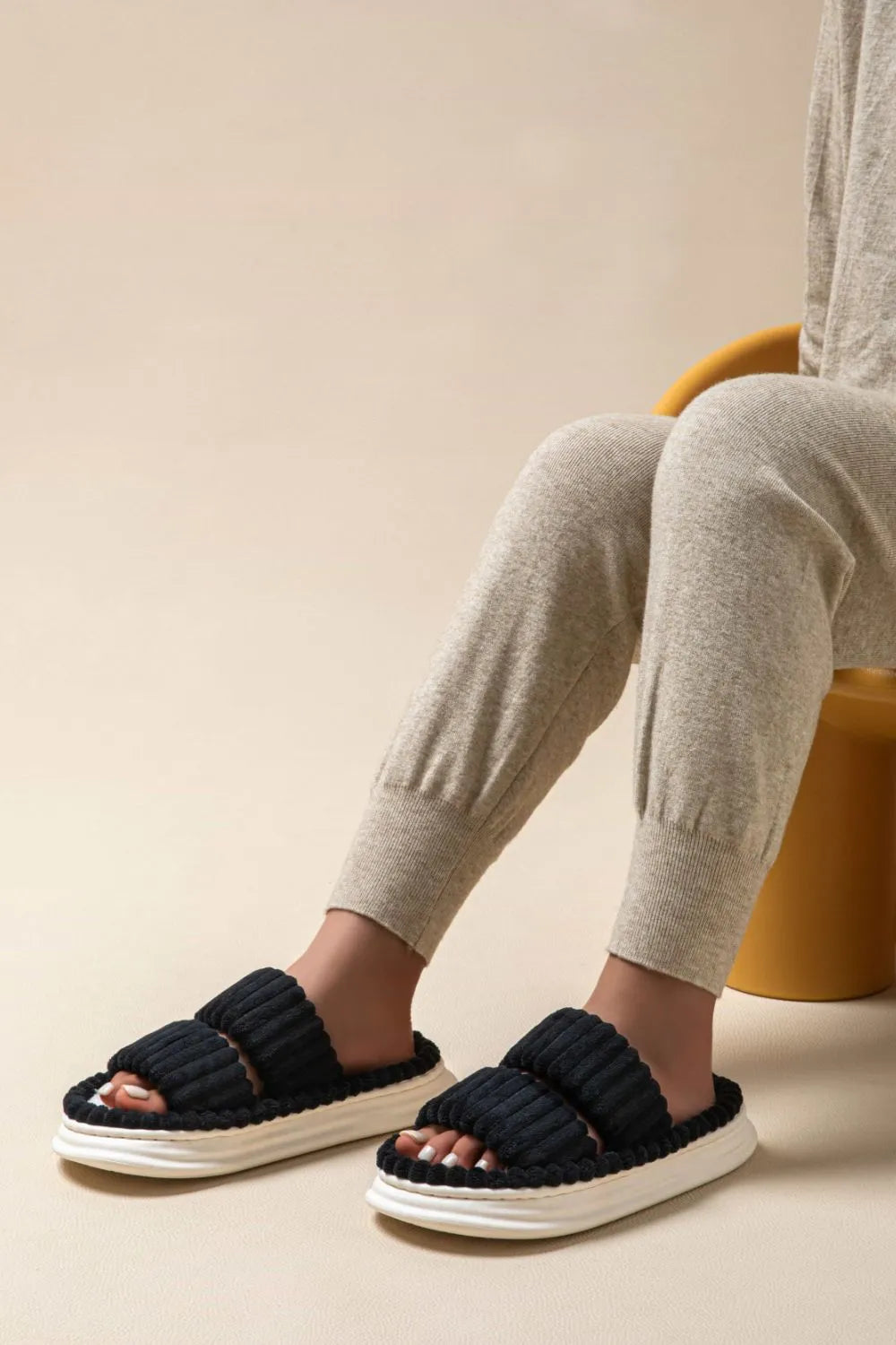 Black ribbed terrycloth platform slides with double straps and white soles.