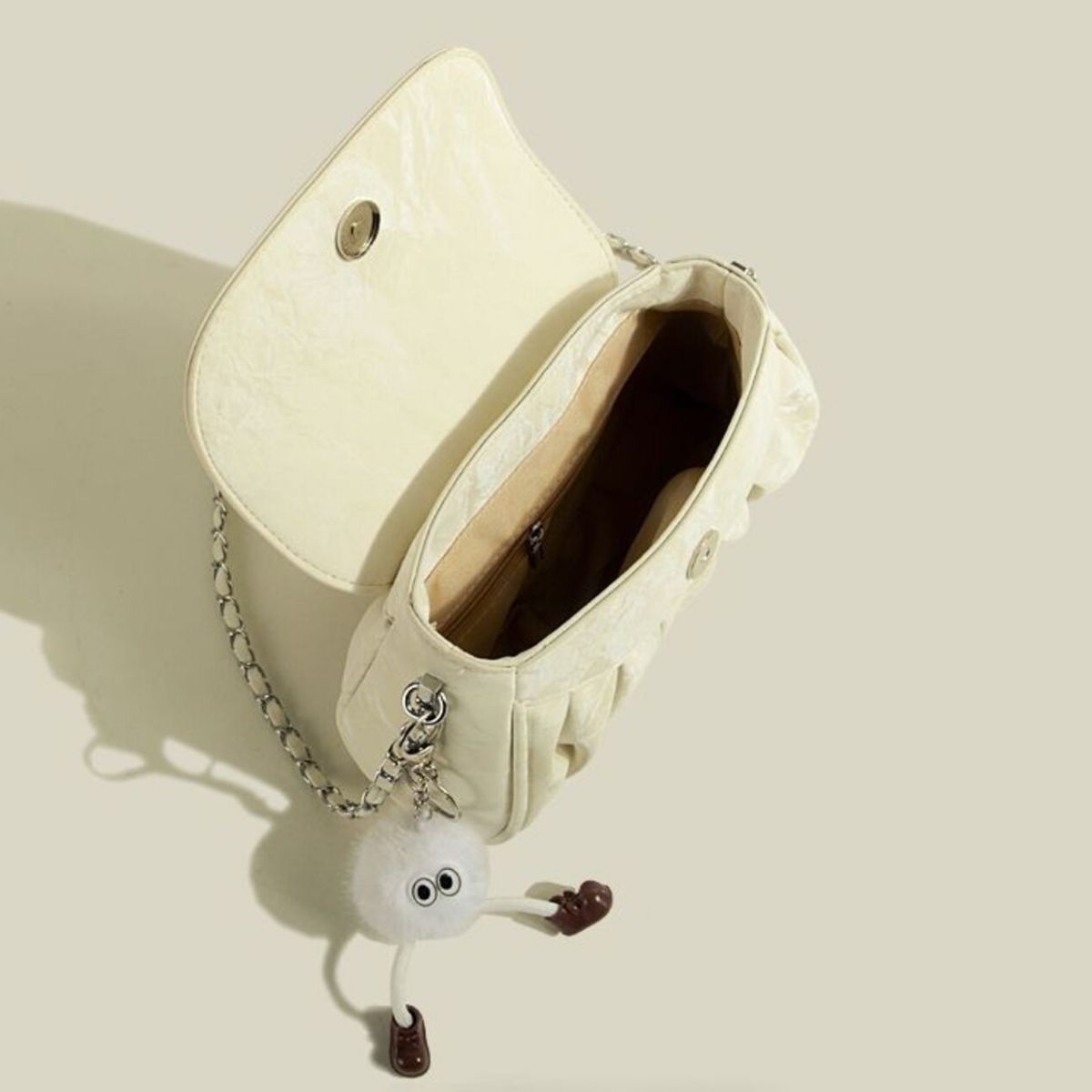 Mini ruched PU leather shoulder bag in pastel yellow with chain strap and fluffy charm.