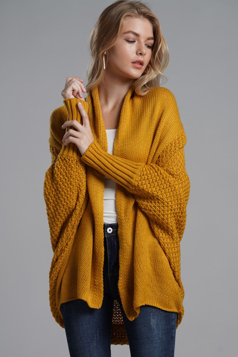 Mustard knit cardigan with drape front, batwing sleeves and textured detail.