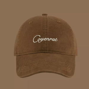 Brown baseball cap with white embroidered text and stitched brim detail.